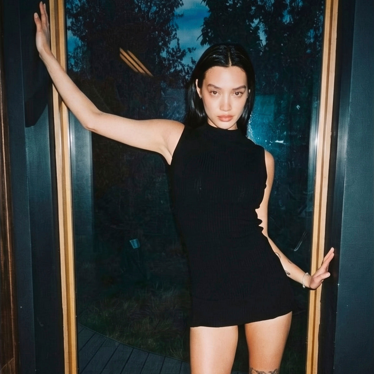 STANDISH. editorial, a model standing in window wearing carbon black tailored knitwear