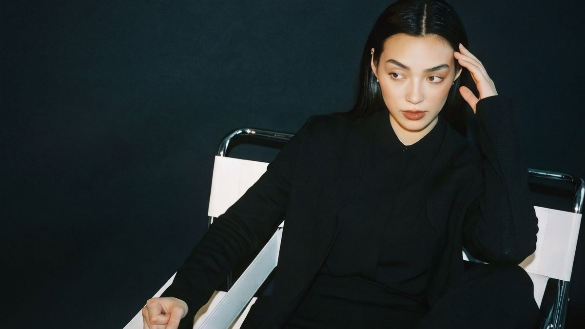 STANDISH. editorial, a model seated in a chair wearing carbon black tailored knitwear
