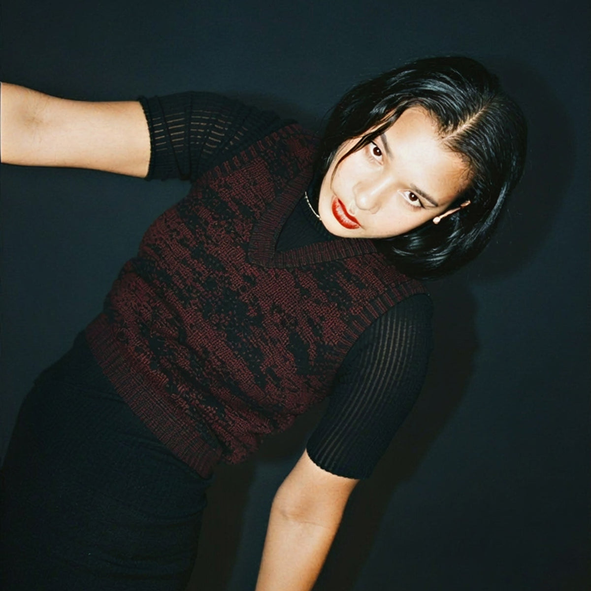 STANDISH. editorial, a model standing 
wearing nocturne magenta carbon black jacquard tailored knitwear